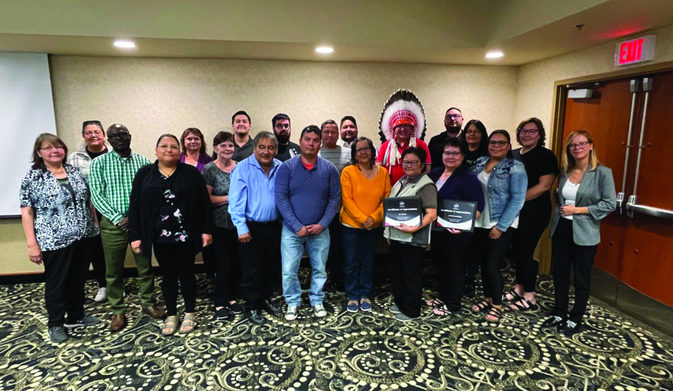 A group of 21 people gather in a group and pose for a photo.