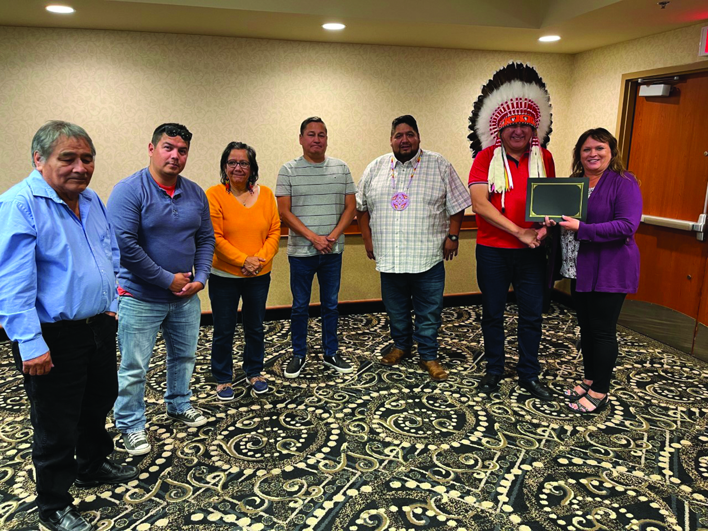 seven people join in a group and pose for a photo.